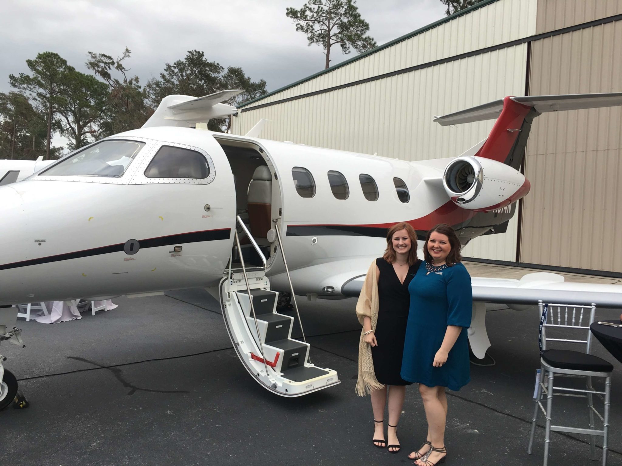 Women Standing Outside of Phenom 300 Aircraft