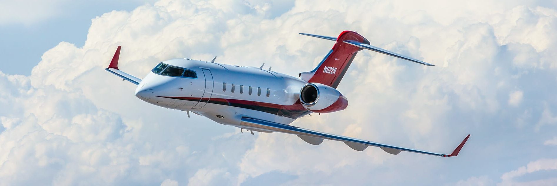 Challenger 300 Against Blue Sky and Clouds