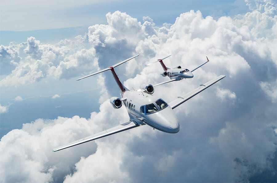 Embraer Phenom 100 & Phenom 300 Flying in Aerial Formation Through Clouds